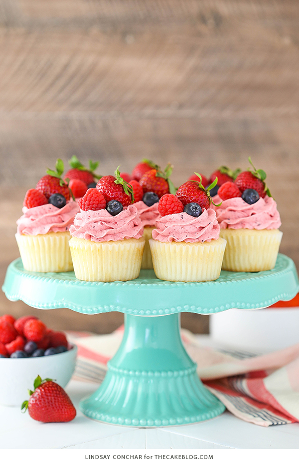 Berries and Cream Cupcakes - mixed berry buttercream paired with a moist vanilla cupcake stuffed with whipped cream cheese filling, topped with fresh strawberries, raspberries and blueberries | by Lindsay Conchar for TheCakeBlog.com