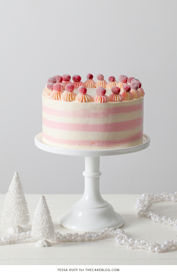 Cranberry Orange Spice Cake - orange cake studded with cranberries topped with white chocolate orange frosting in festive pink and white buttercream stripes | by Tessa Huff for TheCakeBlog.com