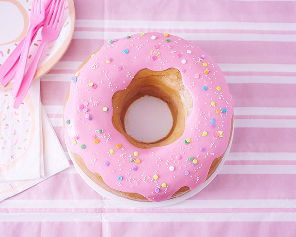 Giant Donut Cake! Learn how to make this adorable, sprinkle-coated, giant donut cake with a simple step-by-step tutorial | by Cakegirls for TheCakeBlog.com