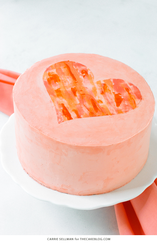Watercolor Heart Cake - how to paint a watercolor heart cake using buttercream frosting and a parchment paper stencil | by Carrie Sellman for TheCakeBlog.com