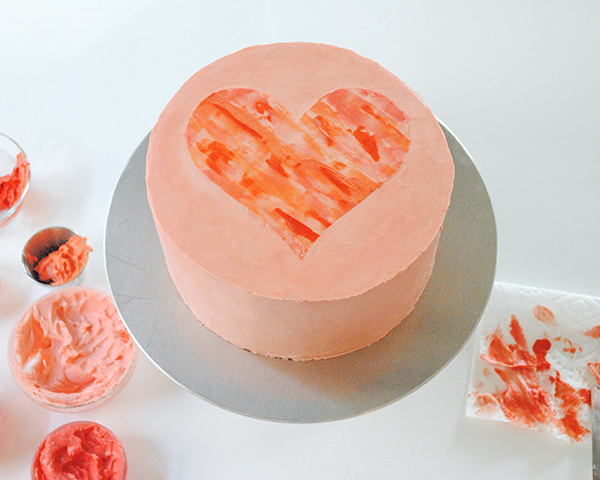 Watercolor Heart Cake - how to paint a watercolor heart cake using buttercream frosting and a parchment paper stencil | by Carrie Sellman for TheCakeBlog.com