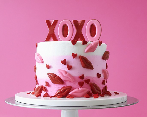 XOXO Valentine's Day Cake - how to make a pink ombre striped cake decorated with chocolate lips, hearts and an XOXO topper | by Cakegirls for TheCakeBlog.com