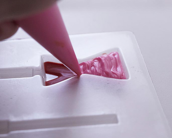 XOXO Valentine's Day Cake - how to make a pink ombre striped cake decorated with chocolate lips, hearts and an XOXO topper | by Cakegirls for TheCakeBlog.com